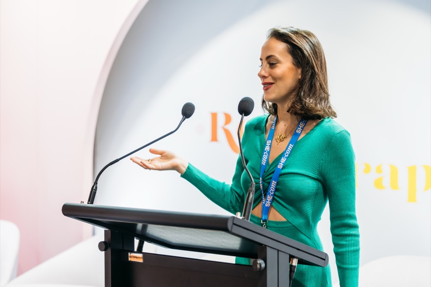 Gabi at the lectern at Reed Gift Fair 2025